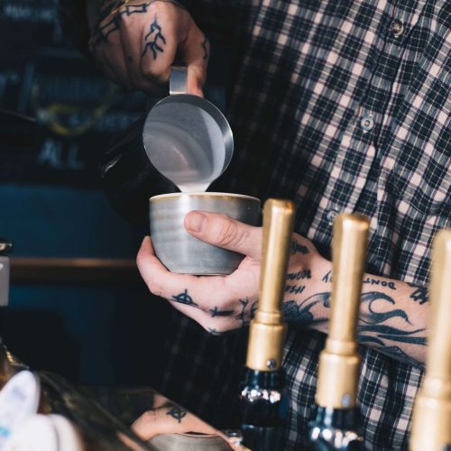 Hot milk being poured into a cup of coffee at The Rosebery